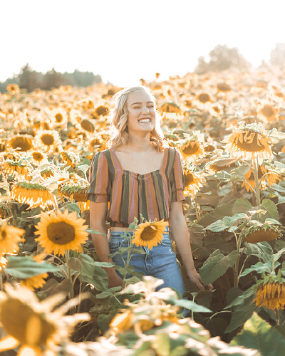 girl standing in sunflower field