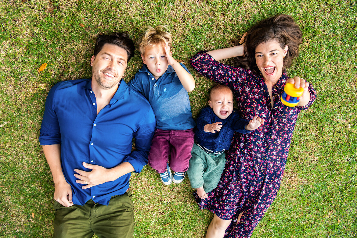 a family photo for 4 laying on the grass