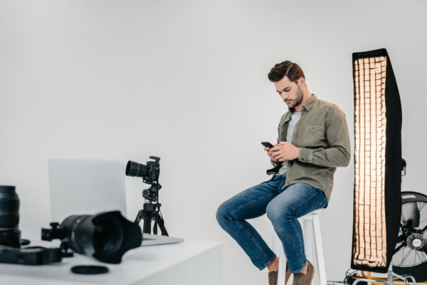 a photographer on his phone sitting in a studio