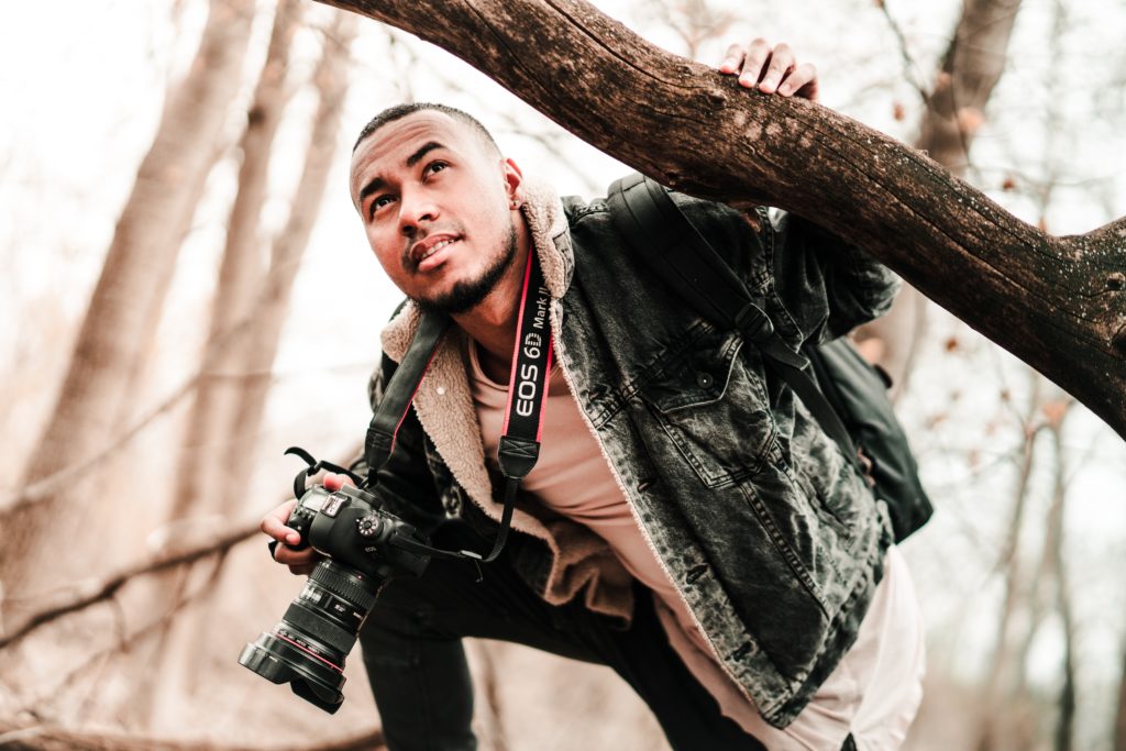 a photographer under a branch of a tree