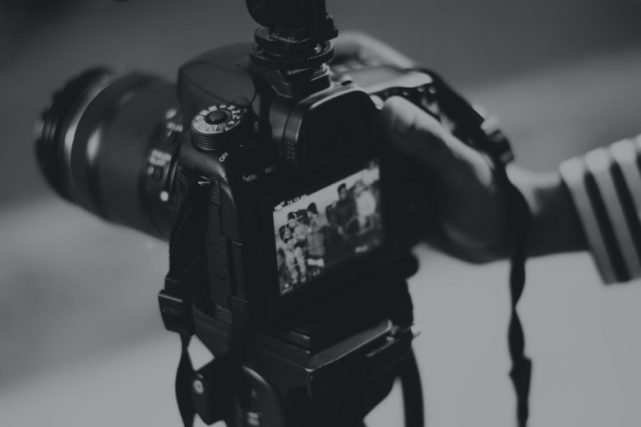 a person holding a DSLR camera